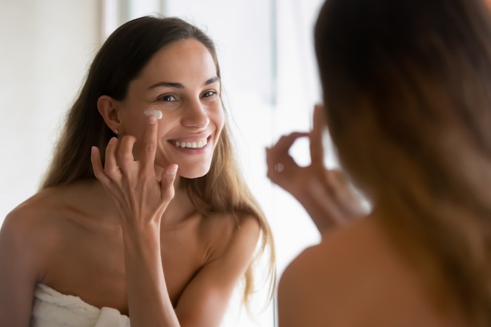 Welche Creme soll ich nach dem Microneedling verwenden? Frau mit Creme im Gesicht