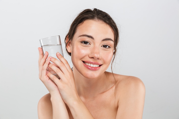 Junge Frau mit Wasserglas Junge Frau mit Wasserglas als Substitut für Polyglutaminsäure (Polyglutamin bzw. PGA) in der Kosmetik