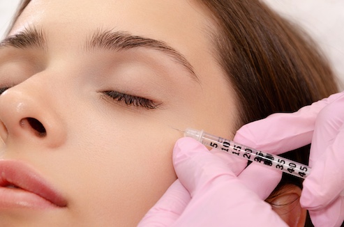 Mesotherapie: Frau bekommt eine Injektion mit einerSpritze